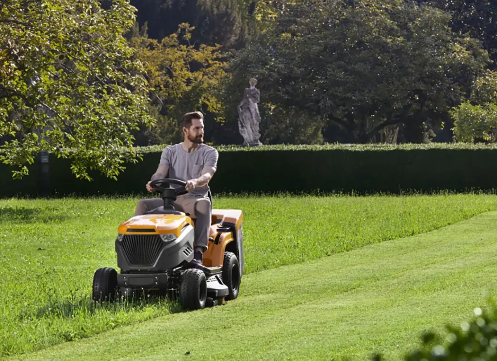 Man operating lawn aerator.